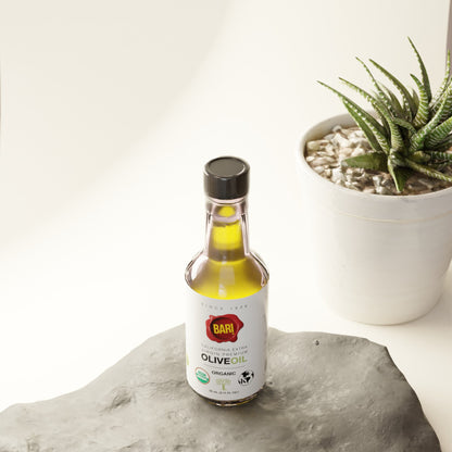 Bari Organic Olive Oil 60mL bottle just sitting on a rock near a potted plant